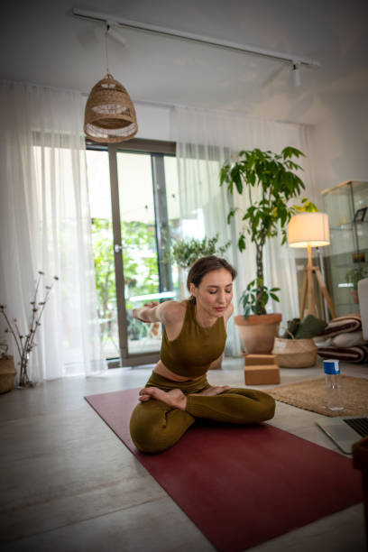 istock Young woman practicing yoga at home 1518440489