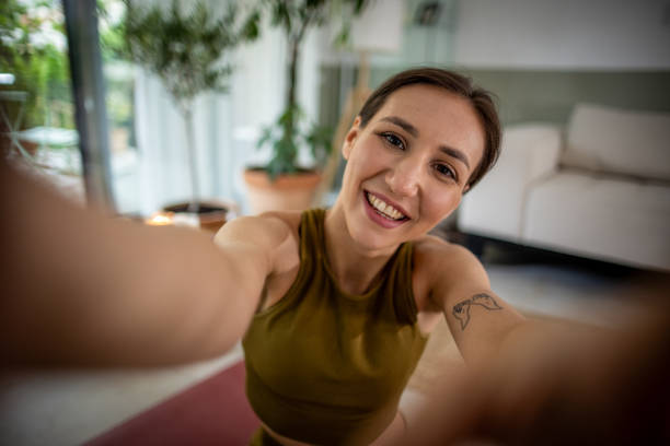 istock Young woman taking selfies while exercising at home 1518451527