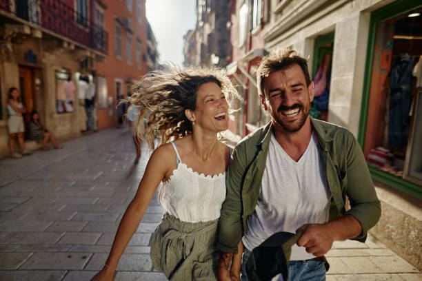 istock Playful couple having fun while running on the street. 1518456293