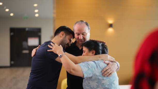 istock Participants of group therapy session hugging each other after finishing group therapy session 1518463648
