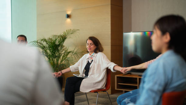 istock Group therapy professional leading group therapy session and meditating 1518490435