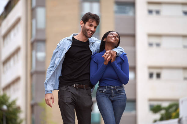 istock Multi-Ethnic couple smiling while walking on the street together. 1518525140