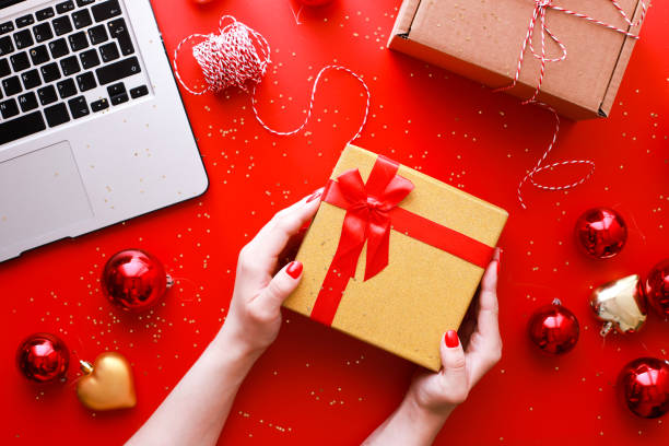 istock Flat lay hands holding a gift with a red bow. Christmas. Online shopping 1518556224