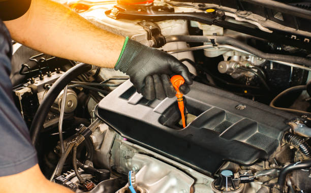 istock Auto mechanic checking the oil level by dipstick 1518557262