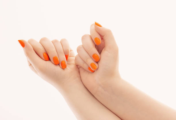 istock female hands with orange manicure   on  white  background 1518562473