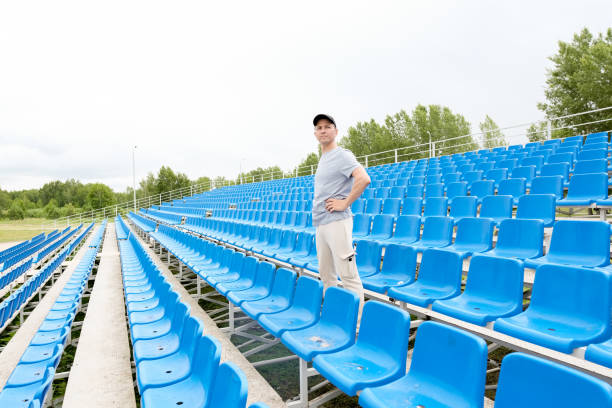 istock A men in black cap stand in stadium background and looking forward. Morning physical jerks outdoor concept 1518564130