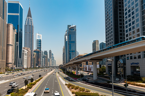 Dubai, United Arab Emirates - April 25th 2023: View into the Sheikh Zayed Road with skyscrapers. Multiple freeway. Overhead railway on the right side.