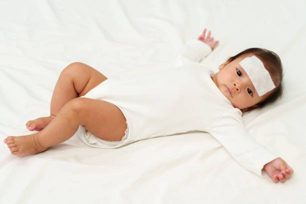 istock sick baby with cool fever jel pad on forehead 1518642914