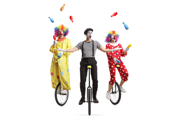 istock Two clowns and a mime riding unicycles and juggling 1518656093