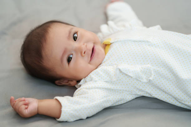 istock happy infant baby smilling while lying on bed 1518685184