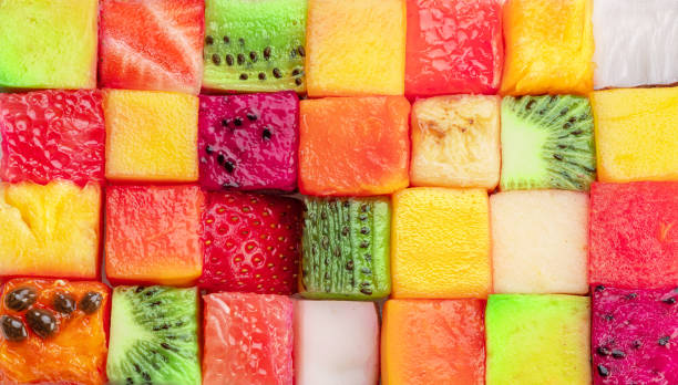 istock Fruit puzzle. Colorful food background or pattern arranged of different fruit cubes. Dietary concept. 1518693776