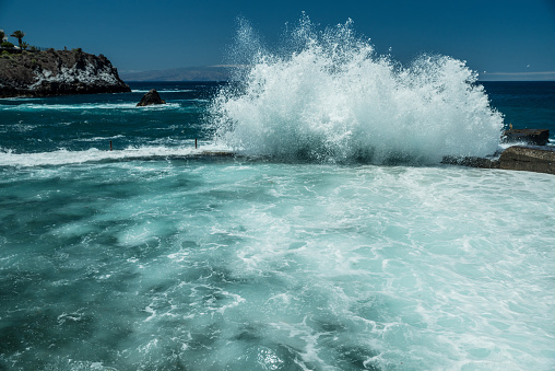 Rocky coastline and big wave breaking on natural swimming pool of Tenerife Island.