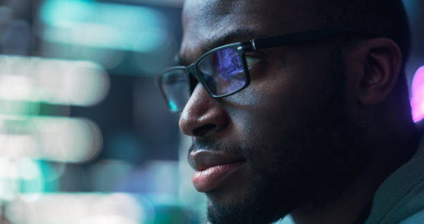 istock Close Up Portrait of Black Man Working on Computer, Lines of Code Language Reflecting on his Glasses. Male Programmer Developing New Software, Coding, Managing Cybersecurity Project 1518853217