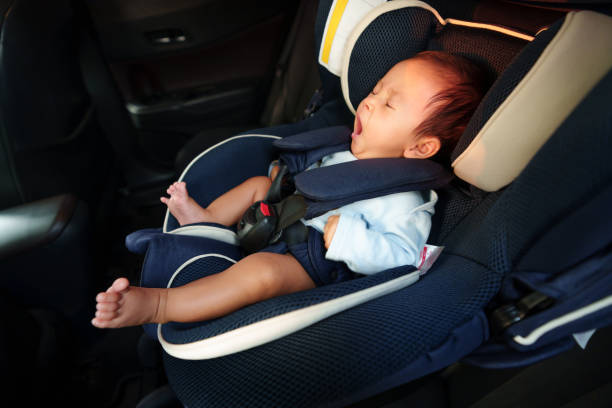 nouveau-né endormi bâillant assis dans un siège d’auto pour bébé, fauteuil de sécurité voyageant - baby yawning asian ethnicity newborn photos et images de collection