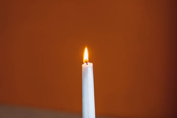 istock A white candle is burning on the table, a warm yellow flame 1518867075