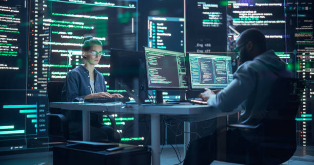 istock Portrait of Two Diverse Developers Working on Computer, Typing Lines of Code that Appear on Big Screens Surrounding Them. Male and Female Programmers Creating Innovative Software Together, Fixing Bugs 1518867614