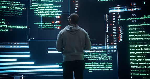 Back View of Young Black Man Looking at Big Digital Screens Glitching While Displaying Code Lines. Worried Professional Programmer Fixing a Bug, Dealing with Crashing System, Ensuring Cybersecurity