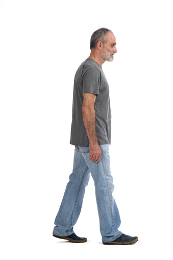 side view of middle aged man walking on white background