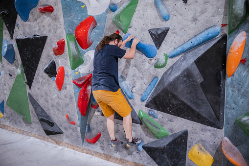 Man enjoying bouldering without any ropes constraining him from being creative in climbing
