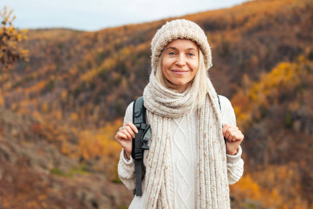 istock Middle Aged Woman with backpack walking in the autumn forest trip 1518922427
