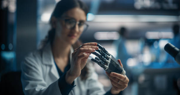 istock Young Female Scientist Working in Technological Research and Development Company, Assembling an Innovative Bionic Prosthetic Hand. Engineer Working on Technology for Physically Impaired People 1518976532