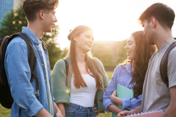 istock Group of four caucasian students standing at university campus and chatting 1518977633