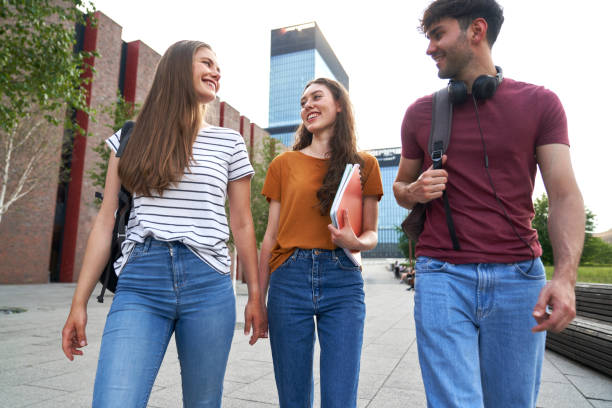 istock Low angle view of group of three caucasian students walking through university campus 1518979990