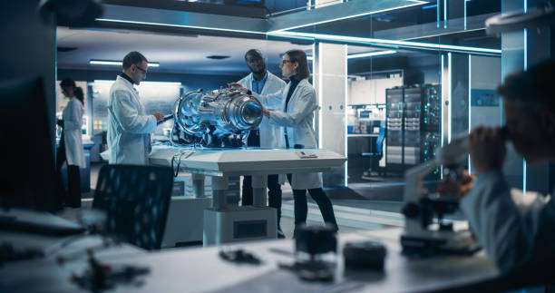 istock Diverse Multiethnic Team of Industrial Engineers Gathered Around a Table With a Prototype Turbine Engine. Scientists Use Tablet Computer to Research, Develop and Program the Futuristic Motor 1518980921