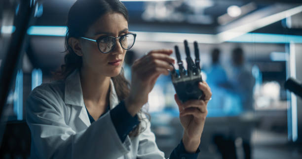 istock Young Scientist Working on a Bionic Robot Hand for People with Health Conditions or Impairments. Female Engineer Using a Screwdriver to Work on Humanoid AI Robot Component at a Startup Company 1518985175
