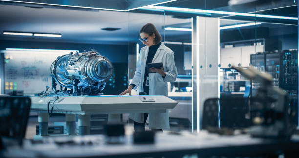 istock Chief Engineer Using Tablet Computer, Analyzing and Researching How a Futuristic Turbofan Motor Works. Female Scientist Developing Innovative Technology in Industrial High Tech Facility 1518990993