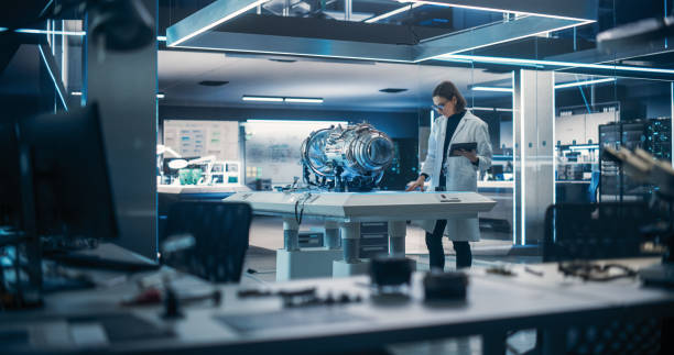 Propulsion Engine Researcher Working on Project with Futuristic Turbine Motor, Standing with Tablet Computer in Scientific Technology Lab. Female Science Professor Developing a Jet Engine