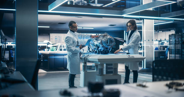 istock Young Engineers Using Tablet and Laptop Computers, Collaborate on a New Type of a Electric Turbine Engine, Using Software for Testing Equipment in Advanced Scientific Technology Laboratory. 1519011759