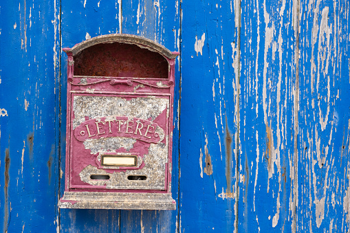 Old red mailbox on a wooden blue wall