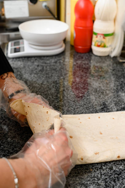 istock The cook in disposable gloves twists the shawarma on the work surface. 1519116687
