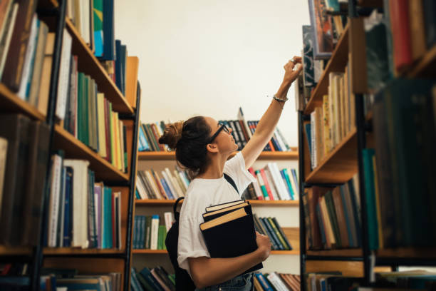 istock A student stuying and reading books in a public library. 1519148625