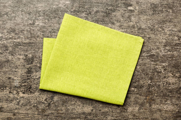 istock top view with green kitchen napkin isolated on table background. Folded cloth for mockup with copy space, Flat lay. Minimal style 1519158500