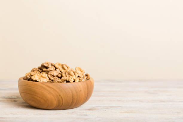 istock Fresh healthy walnuts in bowl on colored table background. Top view Healthy eating bertholletia concept. Super foods 1519158505
