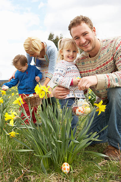 familie auf ostereiersuche in narzissen-feld - daffodil easter egg hunt easter easter egg stock-fotos und bilder