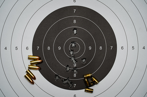 Paper target for shooting with holes from bullets in the center of 9mm cartridges and shells.