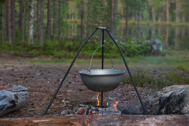 istock a camp pot hangs over the fire on a tripod. Cooking on a camping trip, hiking 1519293862