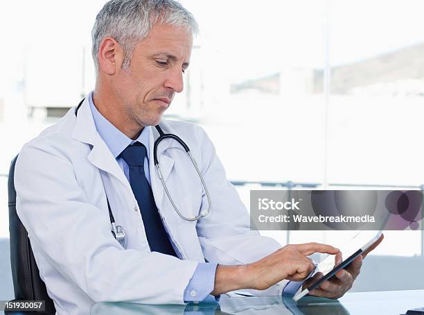 Serious Doctor Working With A Tablet Computer Stock Photo - Download Image Now - Adult, Adults Only, Communication