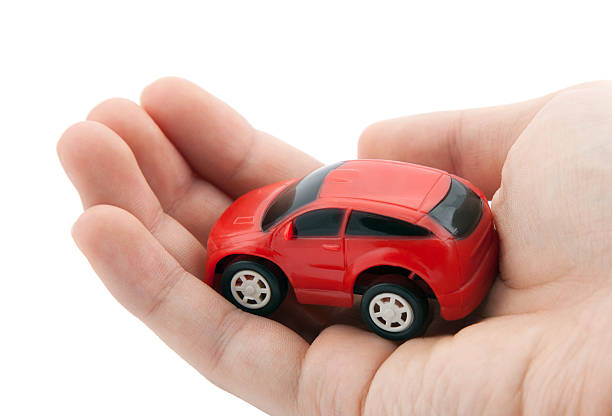 istock Hand holding a small red car. Clipping path included. 151930686