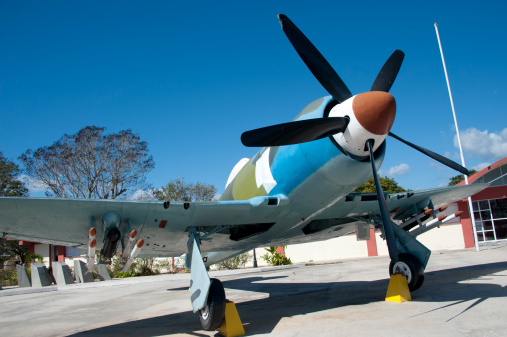 A single engine warplane, or fighter aircraft, sits as a memorial to the Bay of Pigs invasion, Cuba