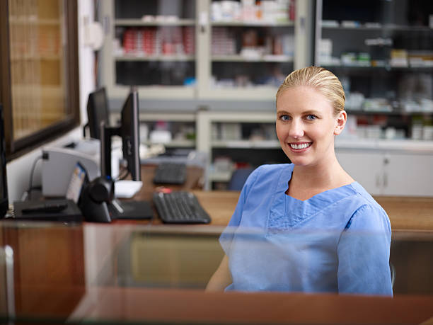 frau arbeitet als krankenschwester an der rezeption in der praxis - female nurse nurse scrubs female doctor stock-fotos und bilder