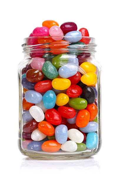Jellybeans in a jar Jelly beans sugar candy snack in a jar isolated on white jellybean photos stock pictures, royalty-free photos & images