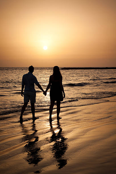 istock Couple Walking by the Ocean Shoreline 151933647
