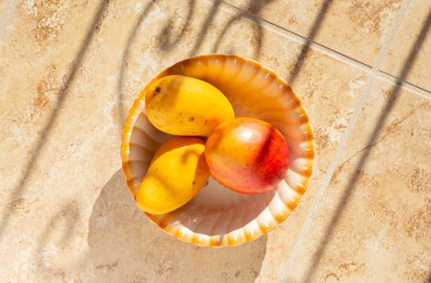 istock Three mangoes in a bowl in early morning llight 1519355323