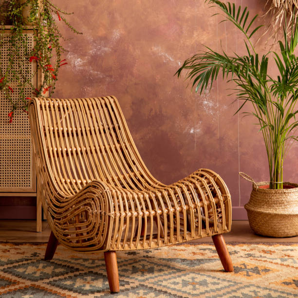 boho-vintage-esszimmer mit rattan-sessel, teppich, kommode und pflanzen. braune wand- und rattanlampe. wohnkultur. schablone. - showcase interior home decorating chair pink stock-fotos und bilder