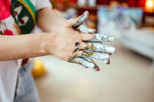 Closeup of woman's hands with paint, artist or creativity concept