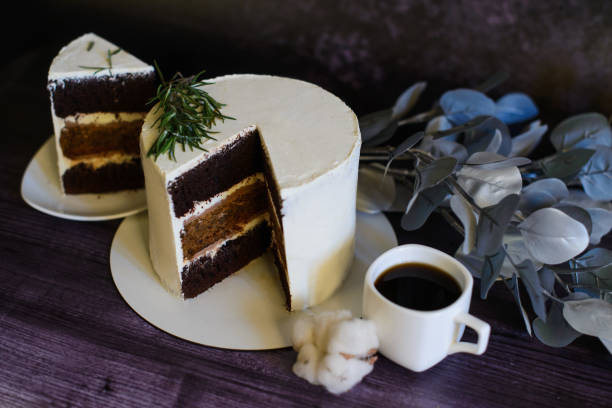 chocolate cake, with a cut piece next to it, on a saucer, and a cup of coffee, on a dark background